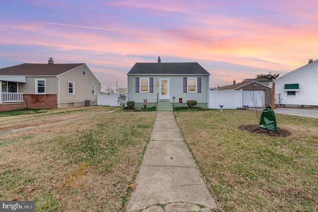 view of front of property with a lawn and cooling unit