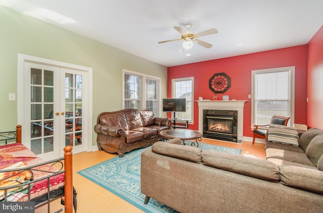 living room featuring hardwood / wood-style floors, plenty of natural light, a high end fireplace, and french doors