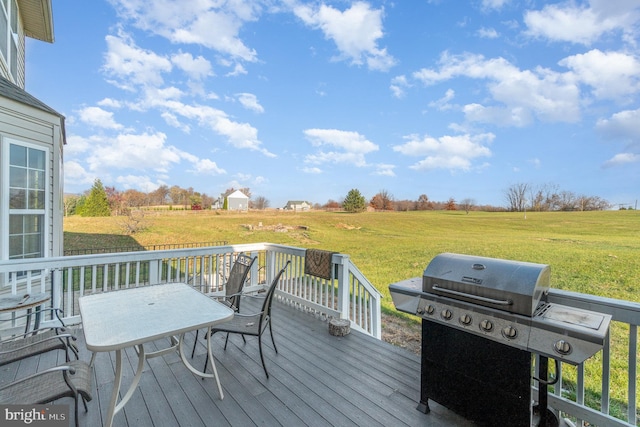 deck featuring a yard, a rural view, and a grill