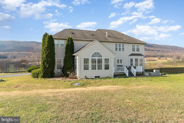 back of house featuring a yard and a deck with mountain view