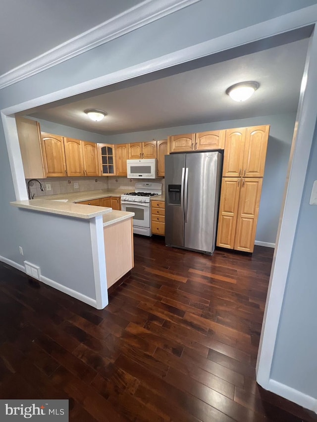 kitchen featuring ornamental molding, backsplash, white appliances, dark wood-type flooring, and kitchen peninsula