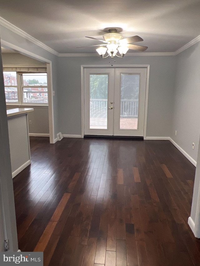 empty room with dark wood-type flooring, plenty of natural light, french doors, and ornamental molding