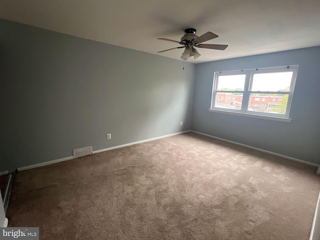 carpeted spare room featuring ceiling fan