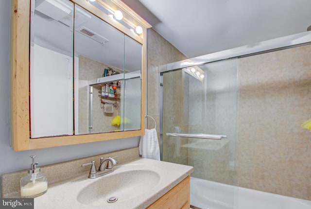 bathroom featuring vanity and bath / shower combo with glass door