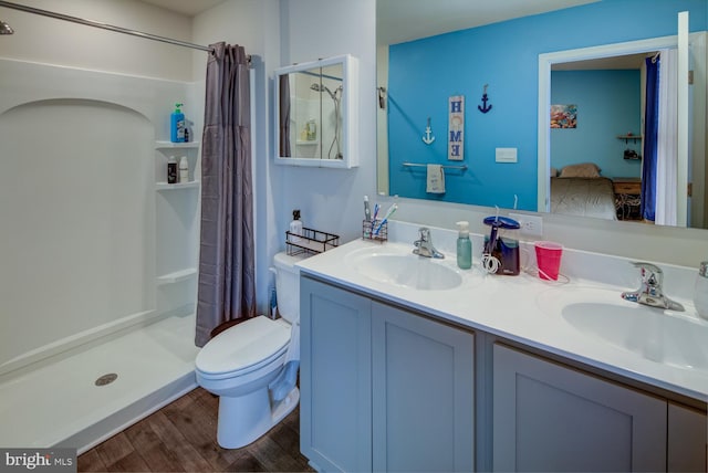 bathroom featuring hardwood / wood-style flooring, vanity, curtained shower, and toilet