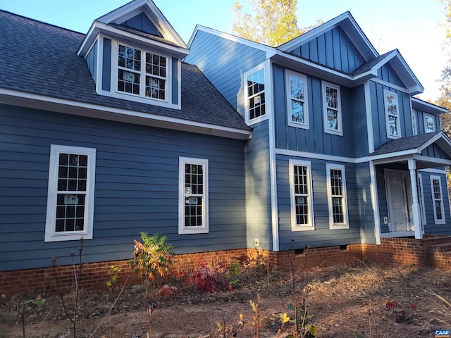 view of home's exterior featuring crawl space, board and batten siding, and roof with shingles