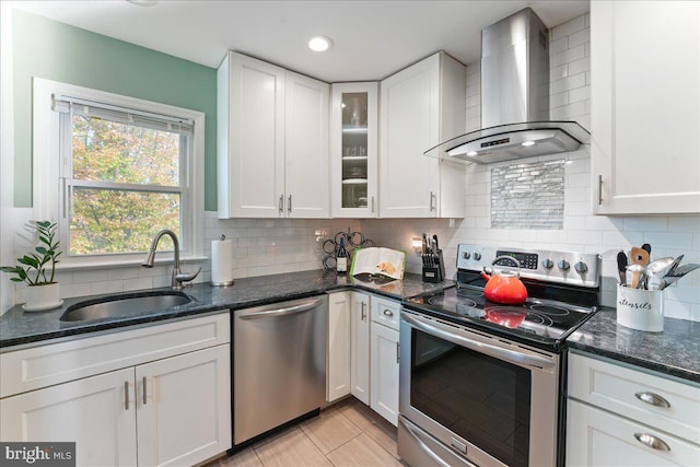 kitchen featuring white cabinets, appliances with stainless steel finishes, sink, and wall chimney range hood