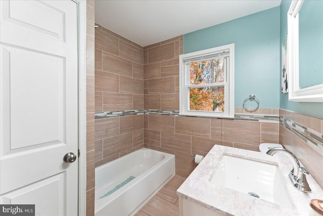 bathroom with vanity, tile walls, and bathing tub / shower combination