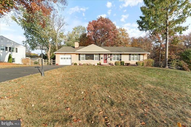 ranch-style house featuring a garage and a front lawn