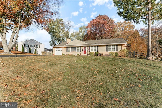 ranch-style home featuring a garage and a front lawn