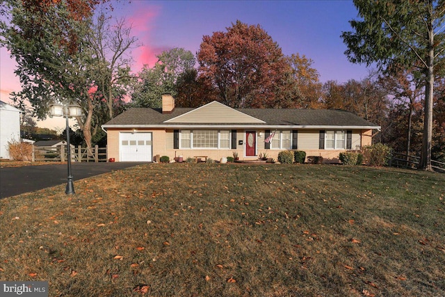 ranch-style home featuring a yard and a garage