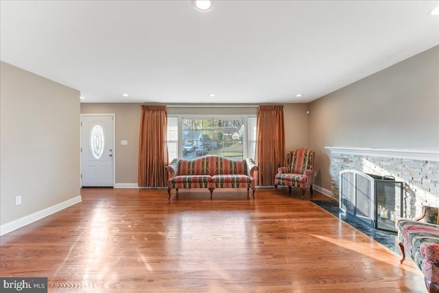 interior space featuring hardwood / wood-style flooring and a stone fireplace