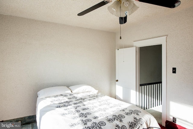 bedroom with ceiling fan and a textured ceiling