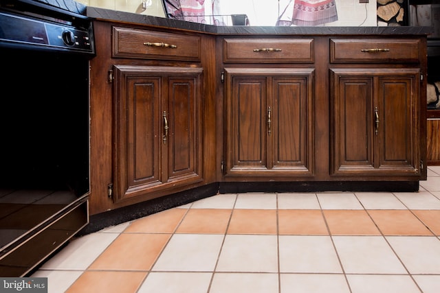 details with dark brown cabinetry and light tile patterned flooring