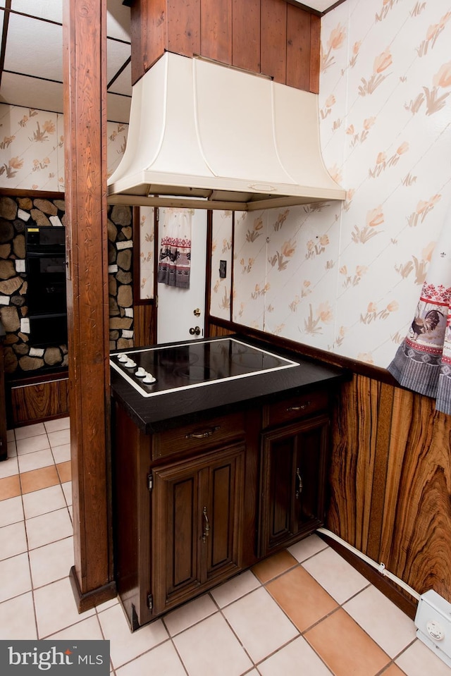 2217 N 59th St, Philadelphia, PA 19131 - kitchen featuring wallpapered walls, exhaust hood, black appliances, wainscoting, and light tile patterned floors