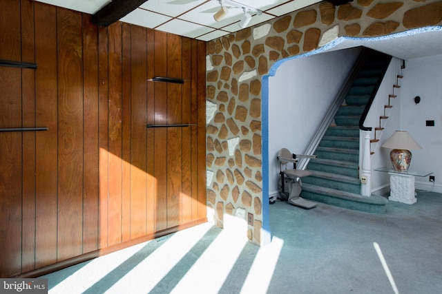 stairs featuring wood walls