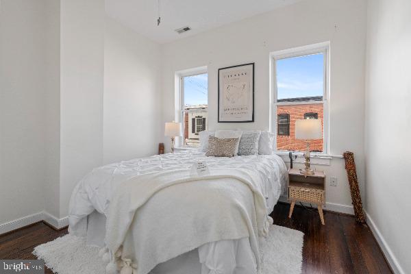 bedroom featuring multiple windows and dark hardwood / wood-style floors