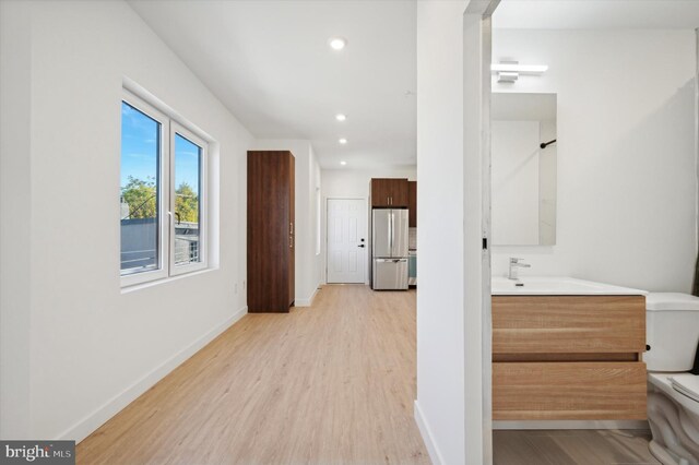 hall featuring light wood-type flooring and sink