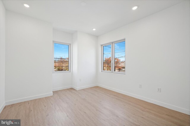 unfurnished room with a healthy amount of sunlight and light hardwood / wood-style flooring