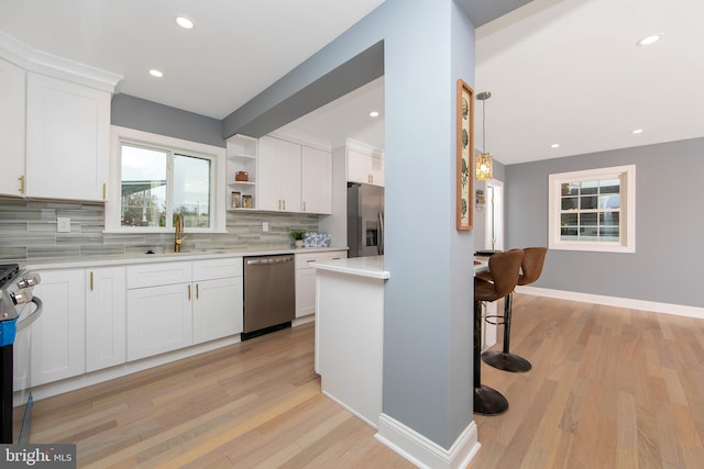 kitchen featuring white cabinets, stainless steel appliances, light hardwood / wood-style flooring, and sink