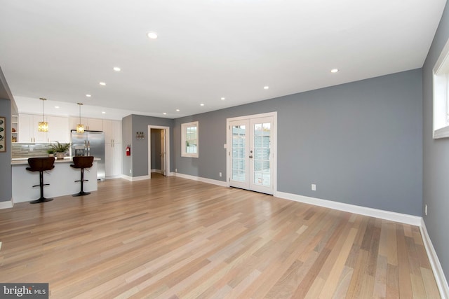 unfurnished living room with french doors and light hardwood / wood-style floors