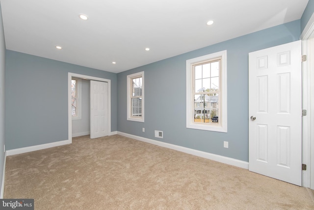 unfurnished bedroom featuring light carpet