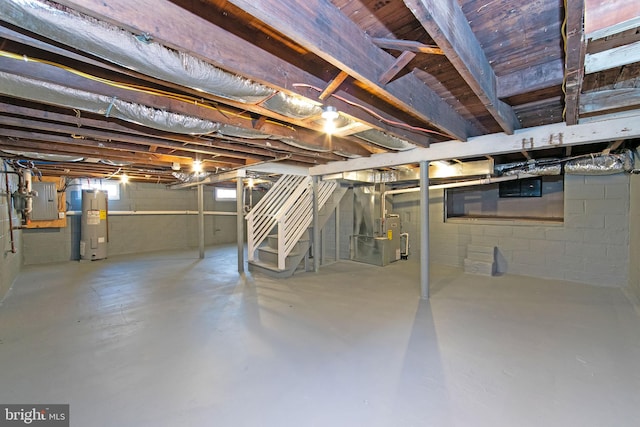 basement featuring electric water heater, electric panel, and heating unit