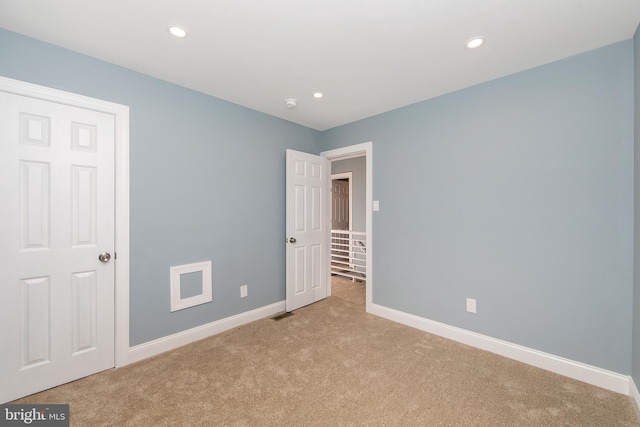 unfurnished bedroom featuring light carpet