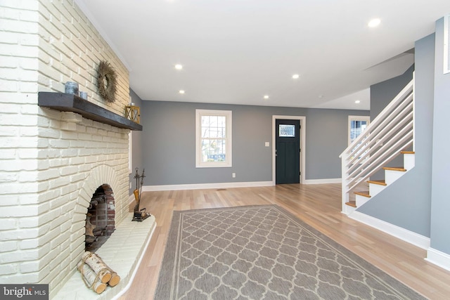 foyer with a fireplace and light wood-type flooring