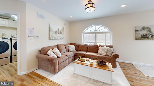 living room with light wood-type flooring and independent washer and dryer