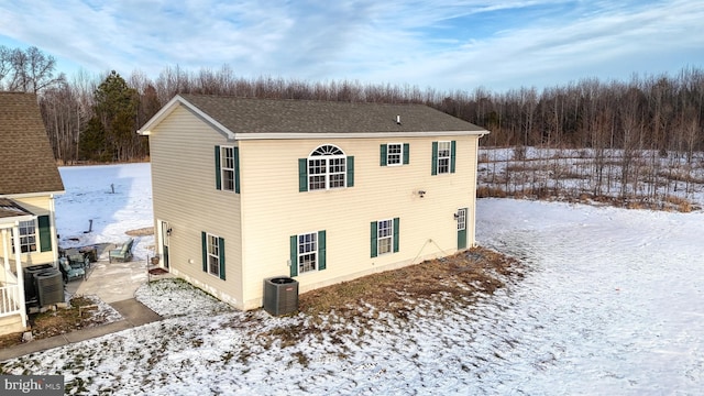 snow covered back of property with central air condition unit