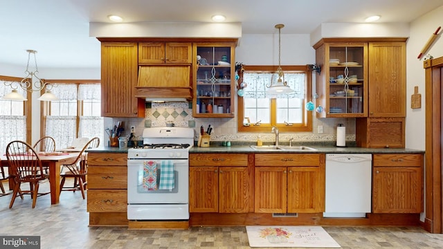 kitchen featuring tasteful backsplash, sink, a chandelier, hanging light fixtures, and white appliances