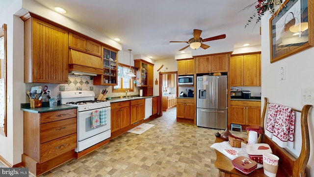 kitchen with premium range hood, pendant lighting, tasteful backsplash, ceiling fan, and stainless steel appliances