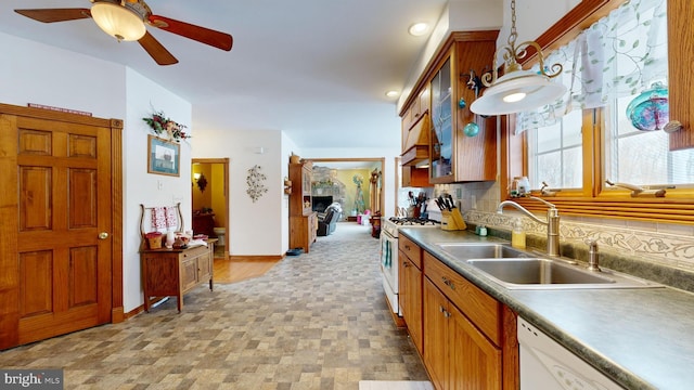 kitchen with tasteful backsplash, white appliances, decorative light fixtures, and sink