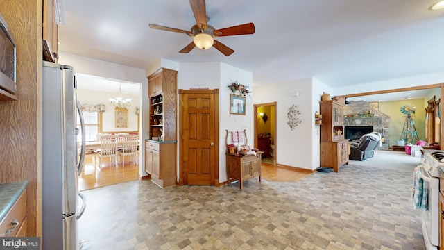 interior space featuring ceiling fan with notable chandelier and a fireplace