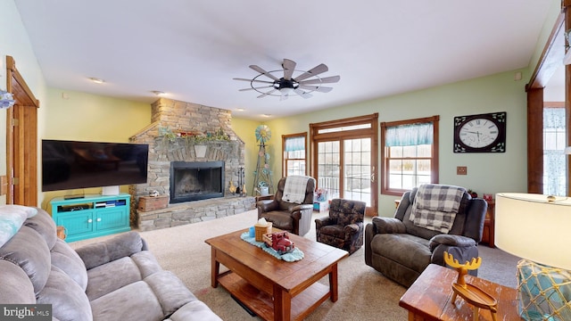 living room featuring light carpet, a fireplace, and ceiling fan