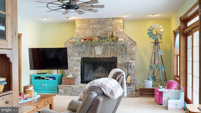 carpeted living room featuring ceiling fan, a healthy amount of sunlight, and a fireplace