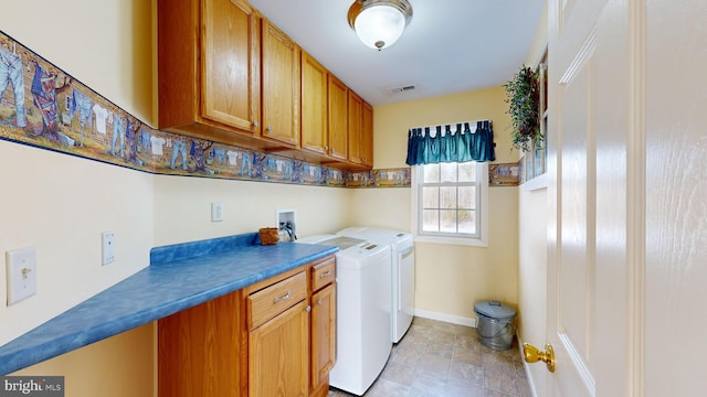 clothes washing area with cabinets and washing machine and clothes dryer