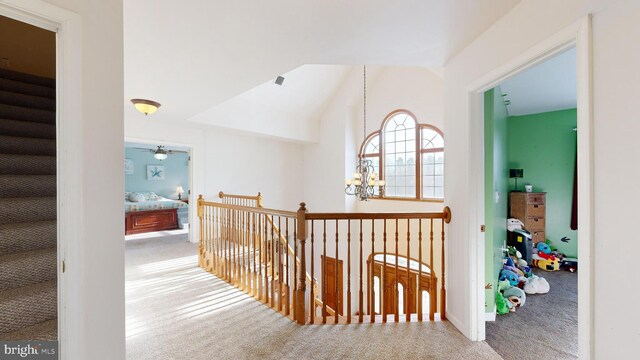 hall featuring an inviting chandelier and carpet flooring