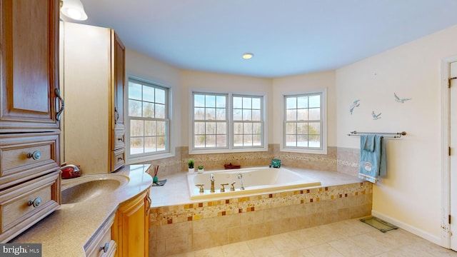 bathroom with vanity, tile patterned floors, and tiled bath