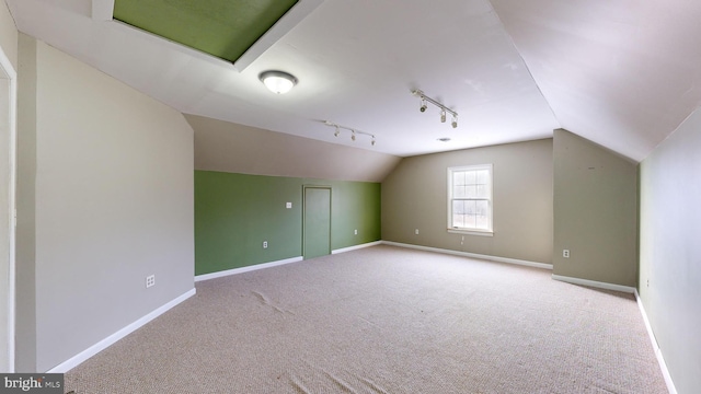 additional living space with vaulted ceiling and light colored carpet