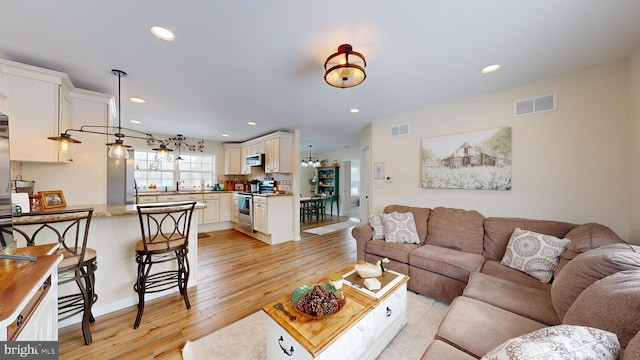 living room featuring sink and light hardwood / wood-style floors