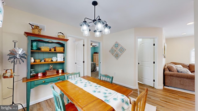 dining space with an inviting chandelier and light hardwood / wood-style floors