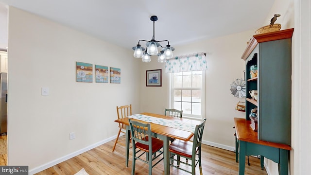 dining room with a chandelier and light wood-type flooring