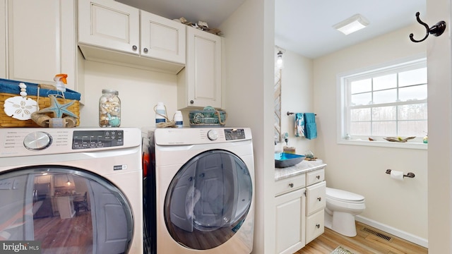 laundry area featuring independent washer and dryer and light wood-type flooring