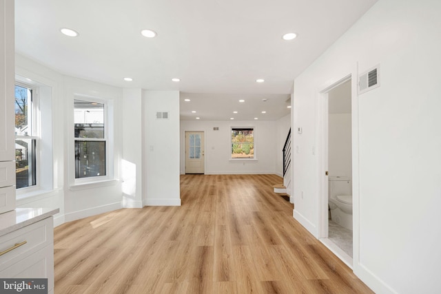 unfurnished living room featuring a wealth of natural light and light wood-type flooring