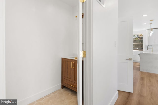 corridor featuring light hardwood / wood-style floors and sink