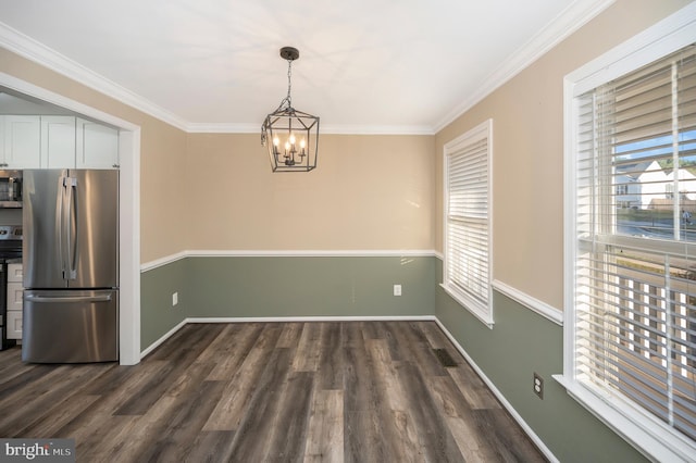 unfurnished dining area with ornamental molding, a chandelier, and dark hardwood / wood-style floors