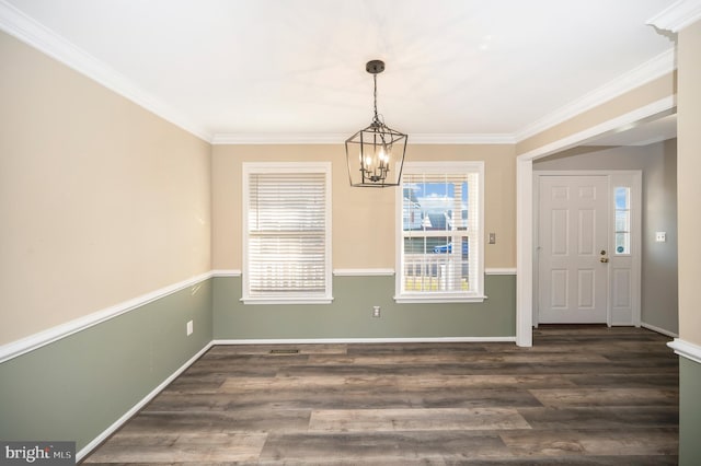 unfurnished dining area with ornamental molding, dark wood-type flooring, and a notable chandelier