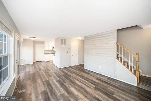 unfurnished living room featuring dark wood-type flooring